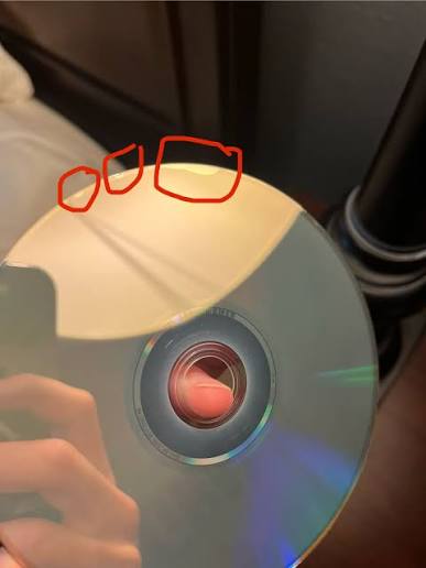 Retro PlayStation and SEGA game discs being inspected for disc rot, scratches and deterioration before safe storage.