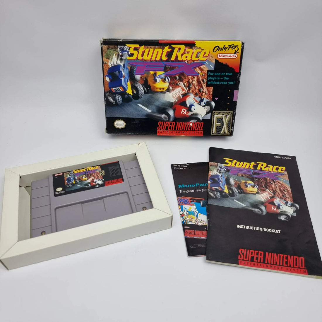 Original retro gaming instruction manuals displayed with classic cartridges, game cases, boxes, and Complete-in-Box video games.